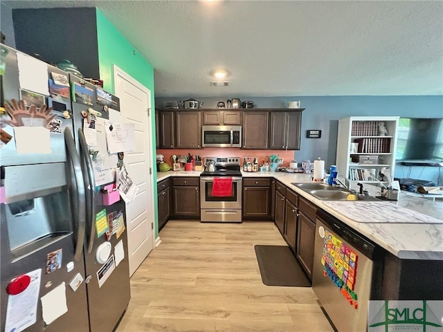 111 Auburn Cir, Glennville, GA 30427 - kitchen with stainless steel appliances, a sink, light wood-type flooring, dark brown cabinetry, and light countertops