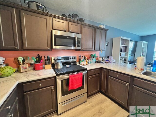 111 Auburn Cir, Glennville, GA 30427 - kitchen with appliances with stainless steel finishes, light wood-style floors, dark brown cabinets, and a sink