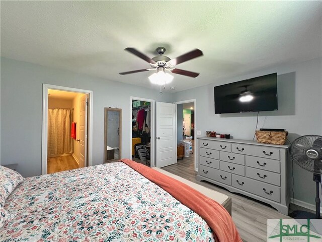 111 Auburn Cir, Glennville, GA 30427 - bedroom featuring light wood finished floors, a spacious closet, a closet, and connected bathroom