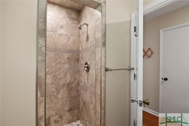 full bathroom with a stall shower, baseboards, and wood finished floors