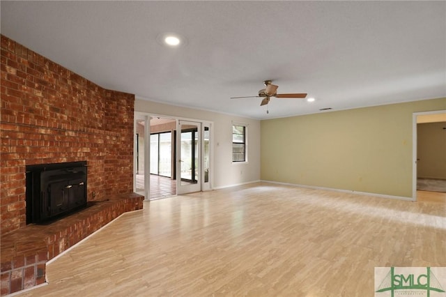unfurnished living room with wood finished floors, ceiling fan, baseboards, recessed lighting, and a wood stove