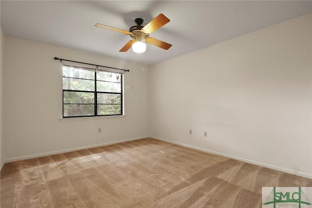 unfurnished room with light colored carpet, ceiling fan, and baseboards