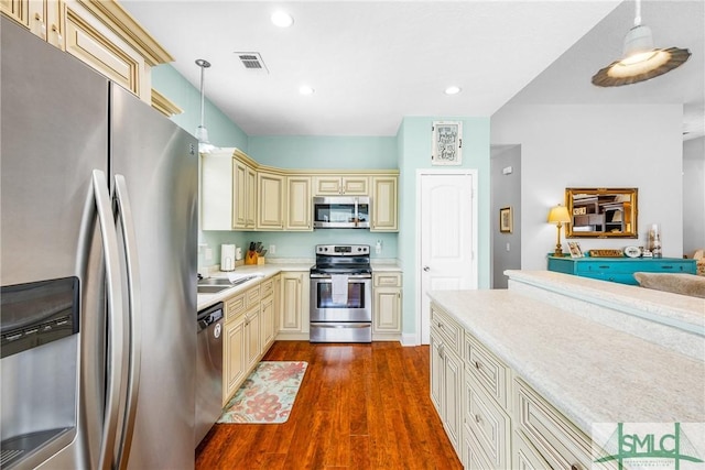 107 Christian Ct, Rincon, GA 31326 - kitchen with stainless steel appliances, cream cabinetry, light countertops, dark wood finished floors, and a sink
