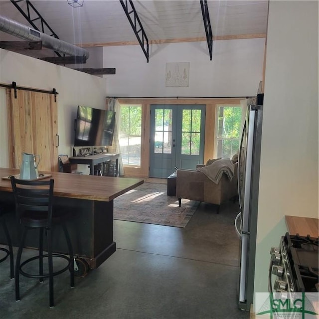 26 Cason Dr, Pembroke, GA 31321 - living area with concrete flooring, french doors, a barn door, and a towering ceiling