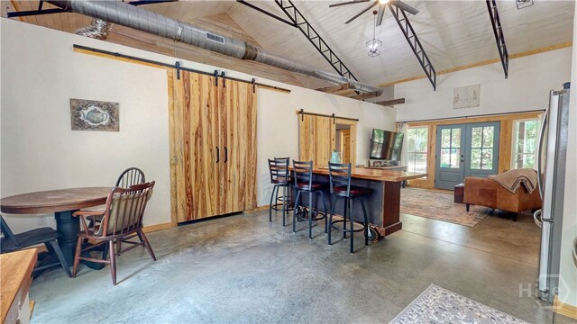 26 Cason Dr, Pembroke, GA 31321 - kitchen with a barn door, concrete flooring, freestanding refrigerator, french doors, and high vaulted ceiling