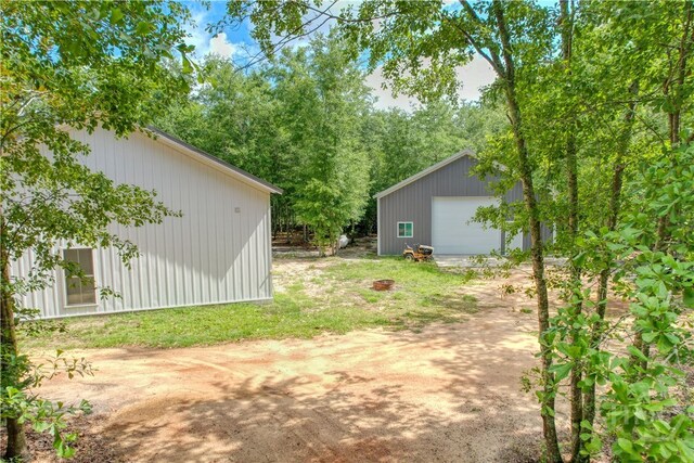 26 Cason Dr, Pembroke, GA 31321 - view of yard featuring an outbuilding, a garage, and dirt driveway