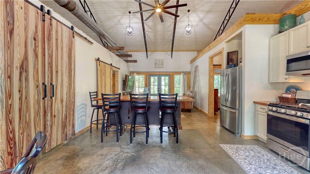 26 Cason Dr, Pembroke, GA 31321 - kitchen featuring appliances with stainless steel finishes, a barn door, finished concrete flooring, and white cabinets