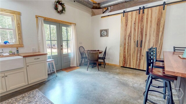 26 Cason Dr, Pembroke, GA 31321 - dining space with finished concrete flooring, a barn door, plenty of natural light, and french doors