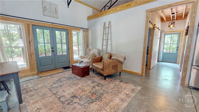 26 Cason Dr, Pembroke, GA 31321 - entryway with a wood ceiling with exposed beams, french doors, a barn door, healthy amount of natural light, and concrete flooring