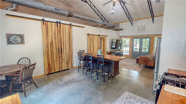 26 Cason Dr, Pembroke, GA 31321 - kitchen featuring a barn door, concrete floors, stainless steel range with gas cooktop, high vaulted ceiling, and french doors