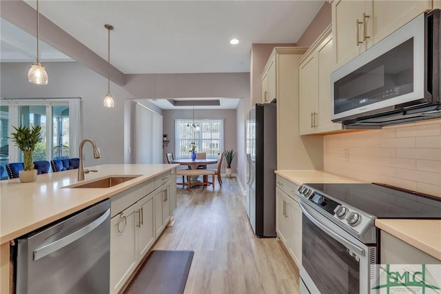 206 Park Chase Chase, Pooler, GA 31322 - kitchen featuring appliances with stainless steel finishes, a sink, backsplash, light countertops, and pendant lighting