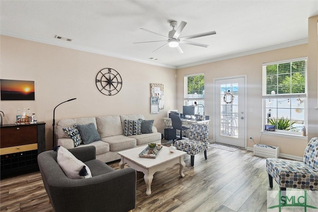 living room featuring wood finished floors, crown molding, ceiling fan, and baseboards