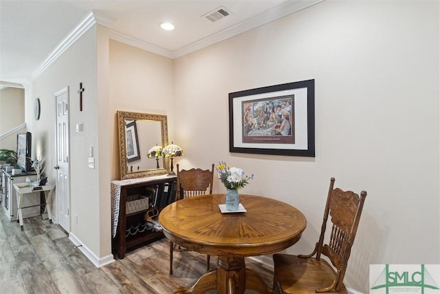 dining area with wood finished floors, baseboards, crown molding, and recessed lighting