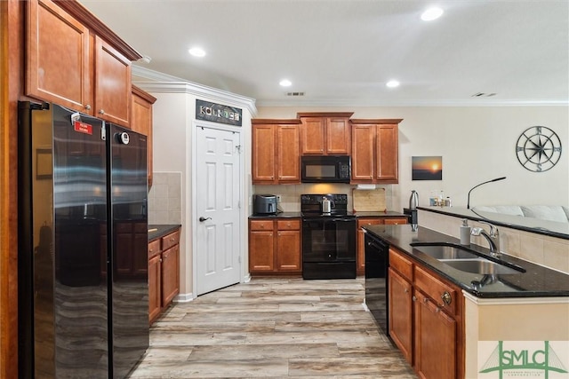 kitchen featuring black appliances, a sink, light wood-type flooring, brown cabinetry, and ornamental molding