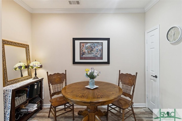 dining space with baseboards, crown molding, and wood finished floors