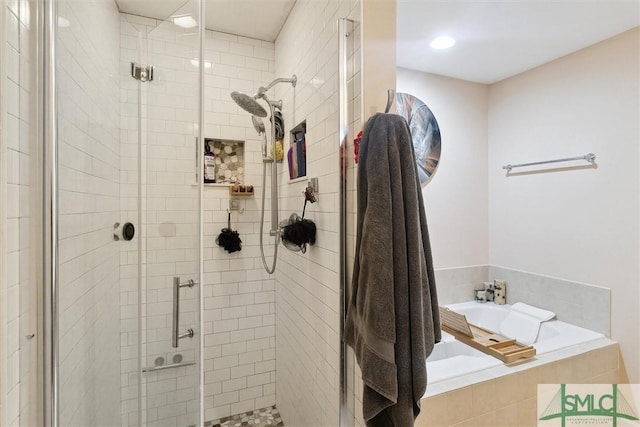 bathroom with a stall shower and a garden tub