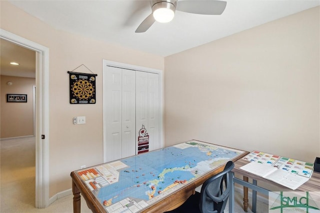 office area featuring light carpet, ceiling fan, and baseboards