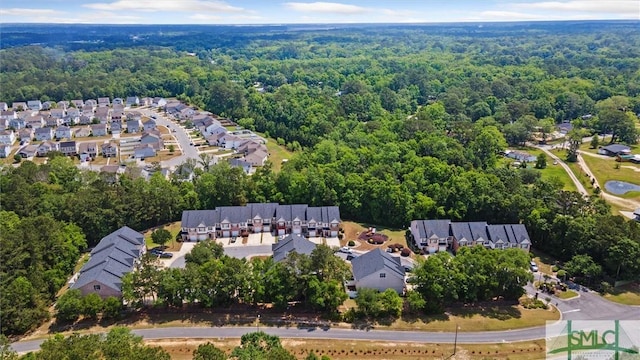 view of property location with a forest and nearby suburban area