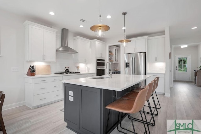 710 Longleaf Dr, Richmond Hill, GA 31324 - kitchen featuring wall chimney range hood, stainless steel appliances, white cabinets, a sink, and light countertops