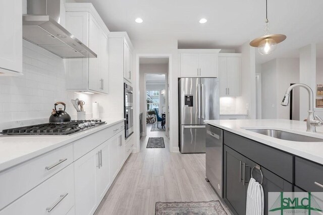 710 Longleaf Dr, Richmond Hill, GA 31324 - kitchen featuring stainless steel appliances, wall chimney exhaust hood, a sink, light countertops, and white cabinetry