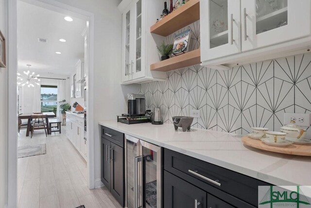 710 Longleaf Dr, Richmond Hill, GA 31324 - kitchen featuring beverage cooler, open shelves, white cabinetry, decorative backsplash, and light countertops