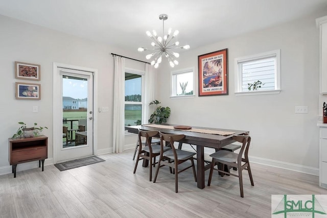 710 Longleaf Dr, Richmond Hill, GA 31324 - dining area with a chandelier, light wood-type flooring, and baseboards