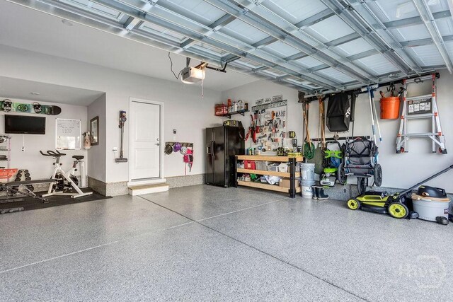 710 Longleaf Dr, Richmond Hill, GA 31324 - garage featuring black fridge and a garage door opener