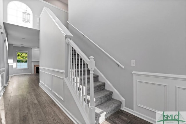 stairs featuring wood finished floors and a fireplace