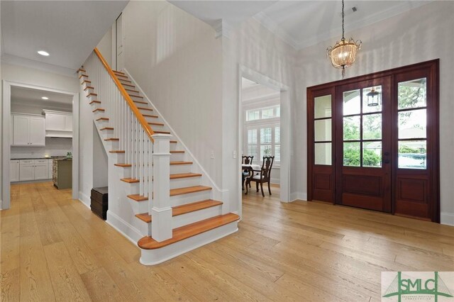 foyer entrance featuring stairs, light wood finished floors, ornamental molding, baseboards, and recessed lighting