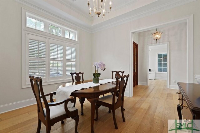 dining room with a chandelier, light wood finished floors, baseboards, and crown molding