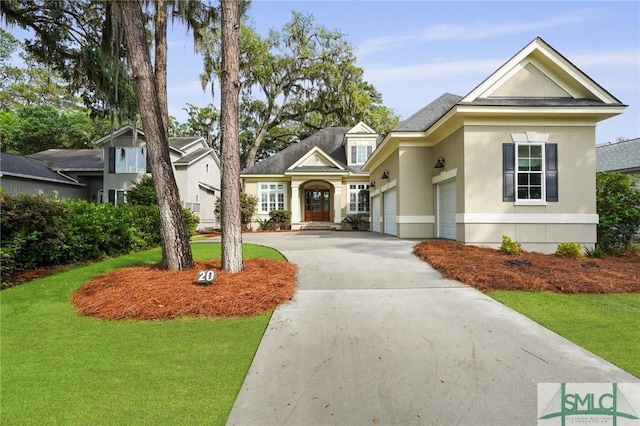view of front of property featuring driveway, a front lawn, stucco siding, and a garage