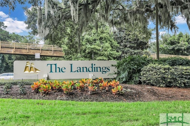 community / neighborhood sign featuring view of wooded area