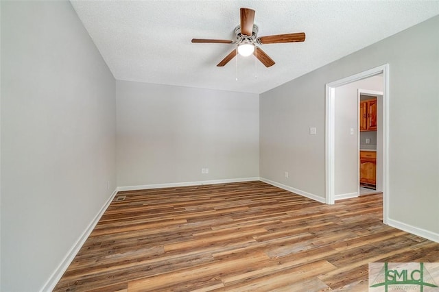 1488 Old Augusta Rd, Clyo, GA 31303 - spare room with wood finished floors, a ceiling fan, baseboards, and a textured ceiling