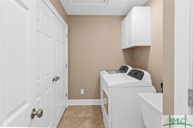 laundry area featuring washer and clothes dryer, cabinet space, and baseboards