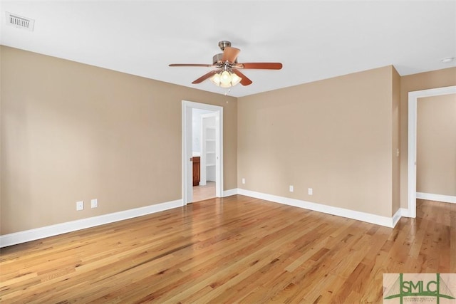 spare room featuring light wood-style floors, ceiling fan, and baseboards