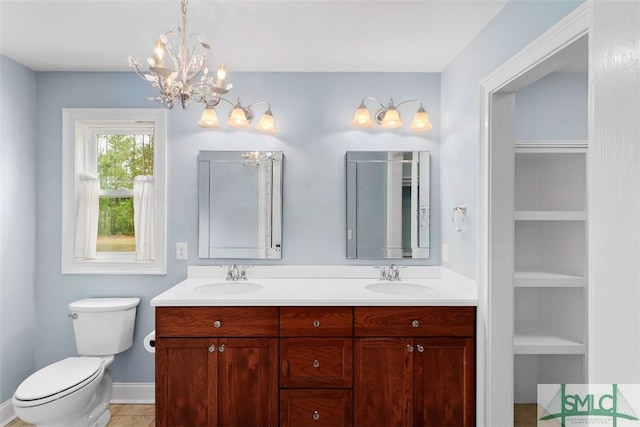bathroom with double vanity, toilet, a chandelier, tile patterned flooring, and baseboards