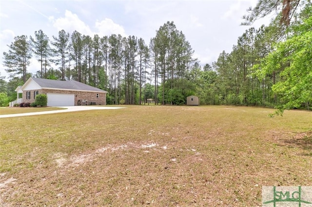 view of green lawn featuring a storage shed, an outdoor structure, an attached garage, and concrete driveway