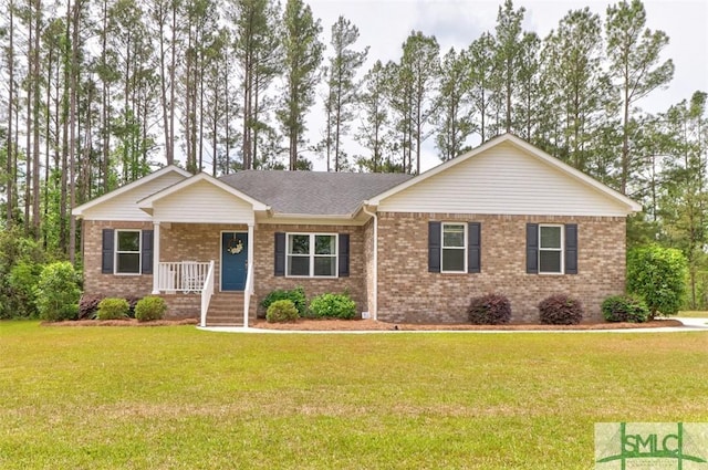 single story home featuring a porch, a front yard, and brick siding
