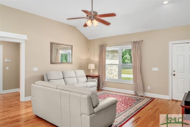 living area featuring light wood-style floors, ceiling fan, baseboards, and vaulted ceiling