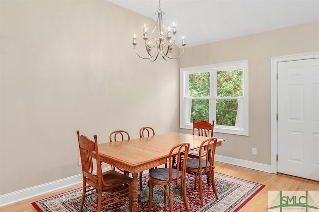 dining space with a chandelier, light wood-style flooring, and baseboards