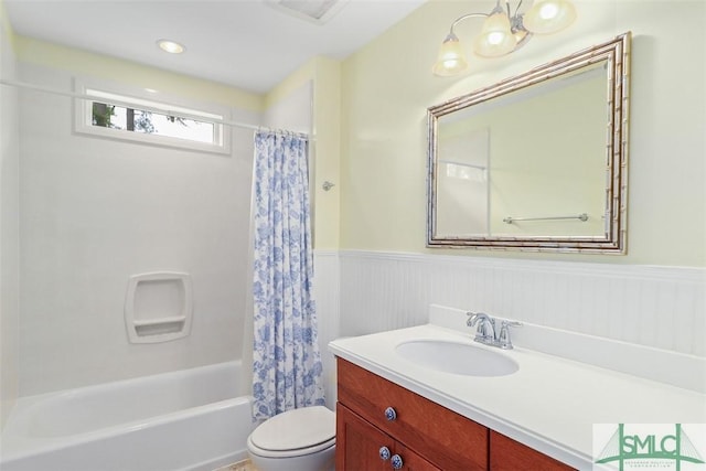 full bathroom with wainscoting, toilet, vanity, and shower / bath combo