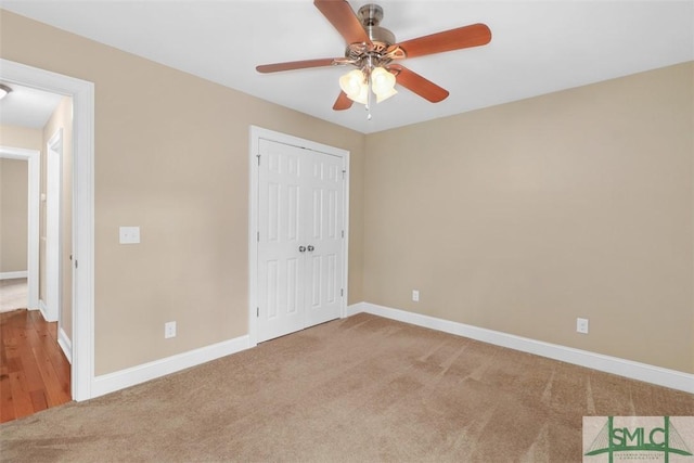 unfurnished bedroom featuring carpet, baseboards, and a closet