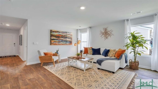 living area with wood finished floors, baseboards, and recessed lighting