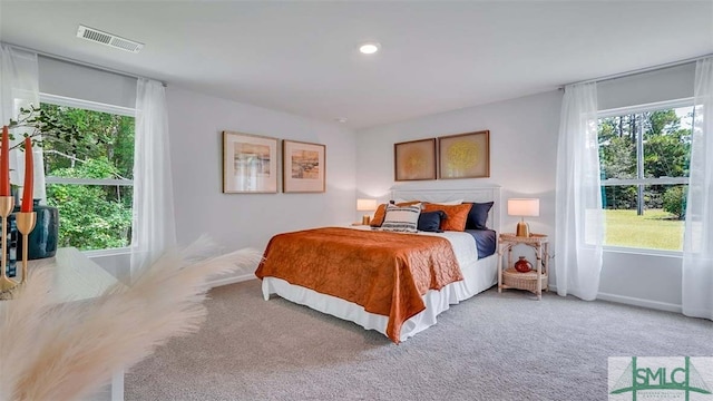 bedroom with light colored carpet and baseboards