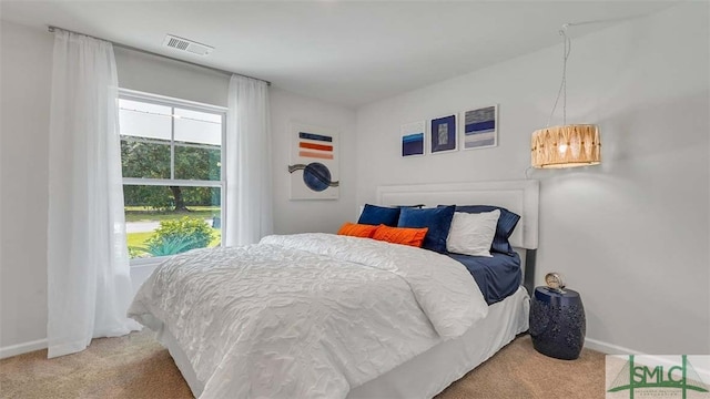 bedroom with light colored carpet and baseboards