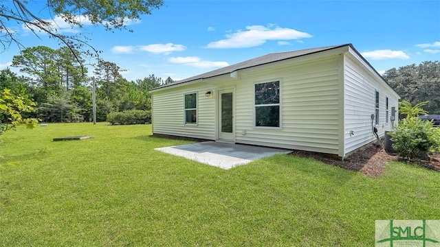 back of property with a lawn and a patio area