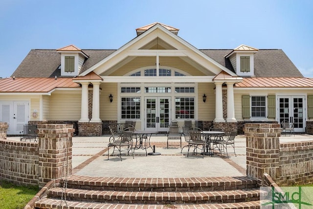 back of property with french doors, a patio, roof with shingles, and metal roof