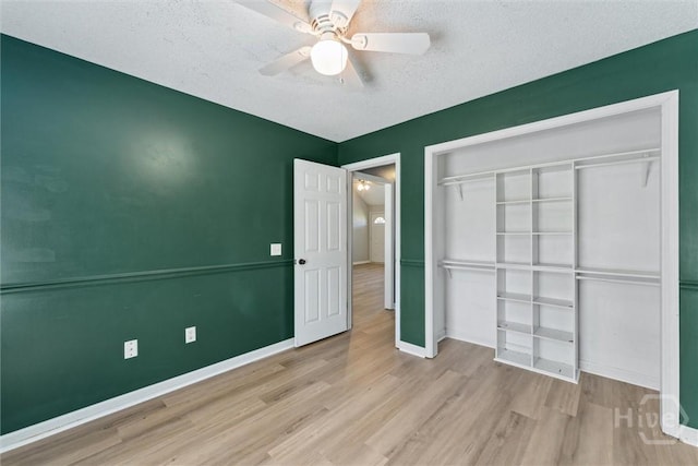 105 Mustang Dr, Guyton, GA 31312 - unfurnished bedroom with wood finished floors, baseboards, a closet, a ceiling fan, and a textured ceiling