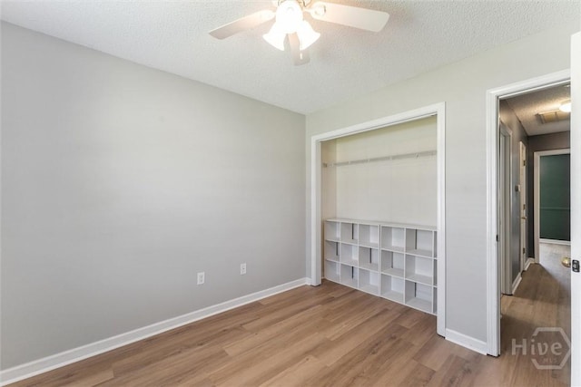 105 Mustang Dr, Guyton, GA 31312 - unfurnished bedroom with wood finished floors, a closet, a textured ceiling, baseboards, and a ceiling fan