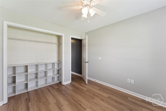 105 Mustang Dr, Guyton, GA 31312 - unfurnished bedroom featuring wood finished floors, baseboards, a closet, a ceiling fan, and a textured ceiling